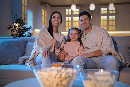 Family watching movie on sofa at night Stock Photo | Adobe Stock